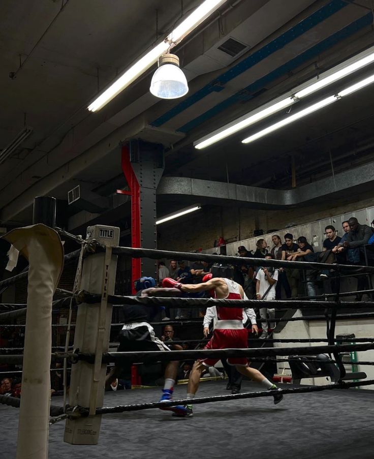 a man standing next to a boxing ring