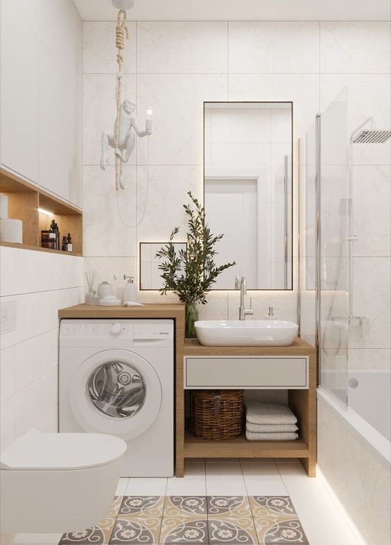 a washer and dryer in a bathroom with tile flooring on the walls