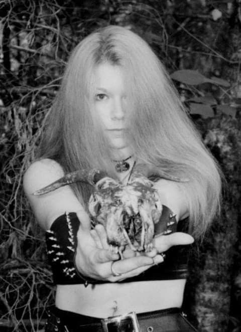 a woman with long hair holding a bird in her hands