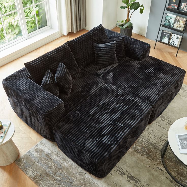 a large black couch sitting on top of a wooden floor