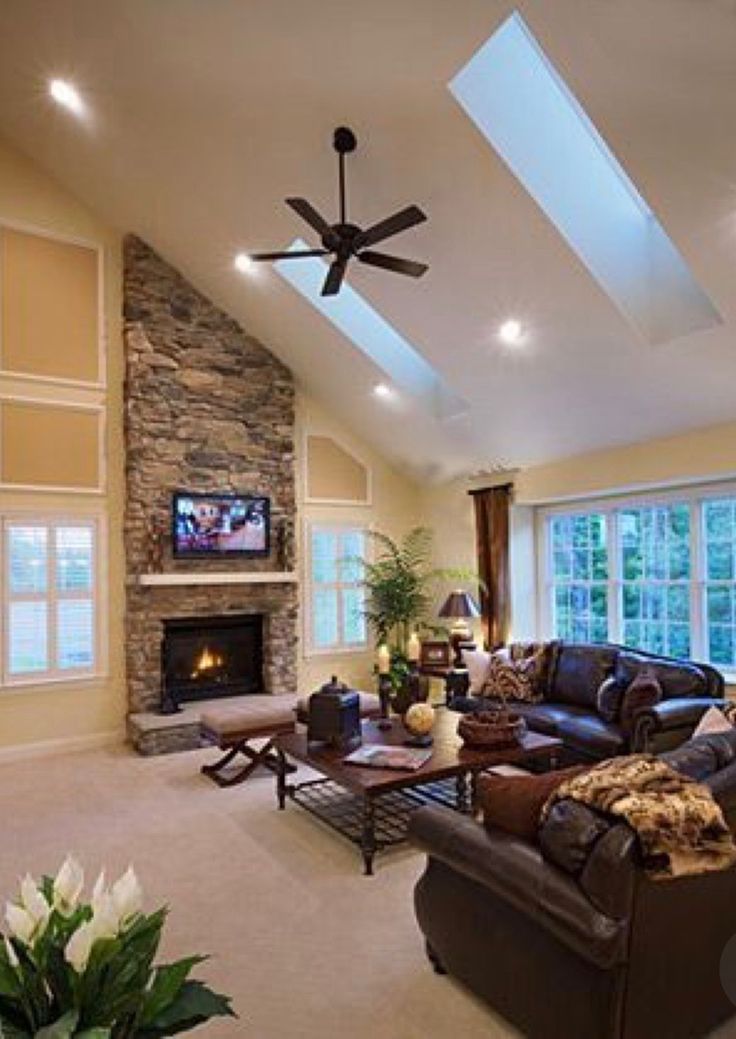 a living room filled with furniture and a flat screen tv mounted on the wall next to a fire place