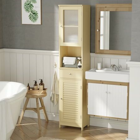 a white bath tub sitting next to a sink and a wooden cabinet in a bathroom