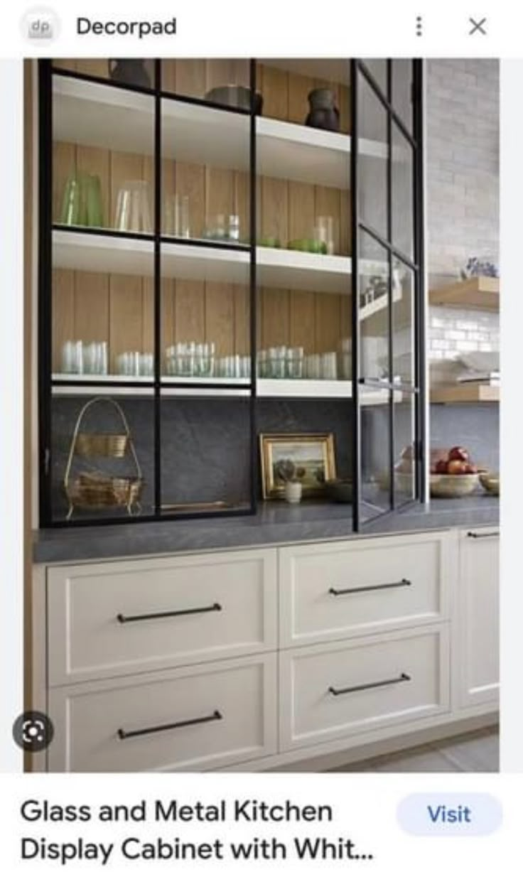 a kitchen with white cabinets and shelves filled with glassware on top of it's counters