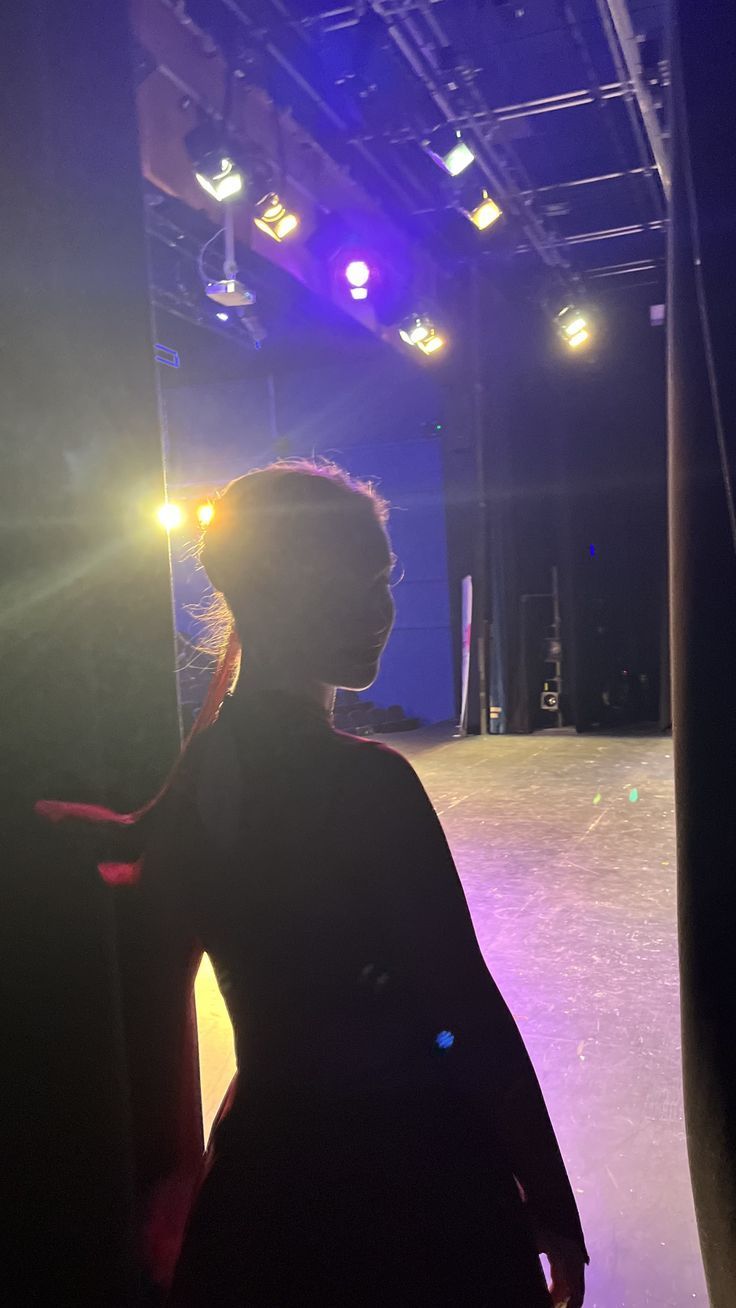 a woman standing in front of a purple light