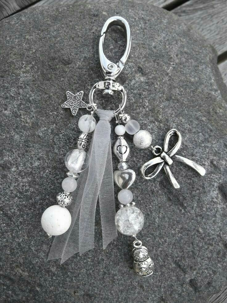 a close up of a key chain on a rock with beads and charms attached to it