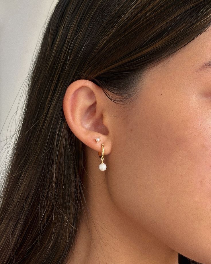 a close up of a person wearing some kind of earring with pearls on it