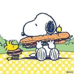 a cartoon character holding a large sandwich in front of him and his dog sitting on the ground