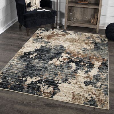 an area rug in a living room with a black chair and bookcase behind it