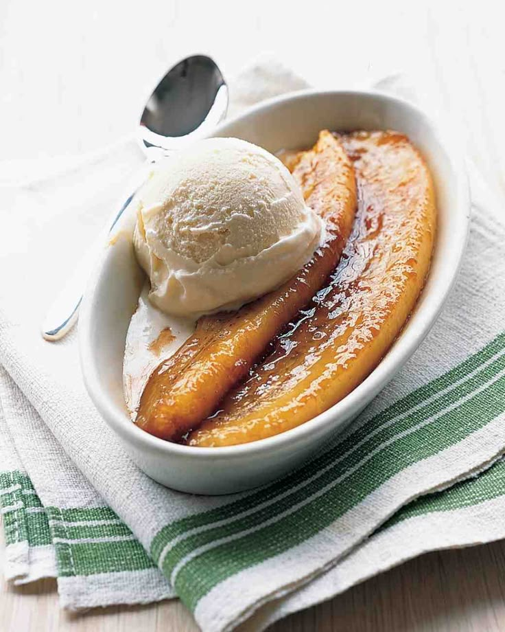 a bowl filled with fruit and ice cream on top of a green and white towel