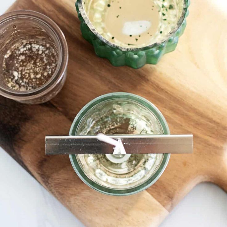 two jars with different types of food in them sitting on a cutting board next to each other