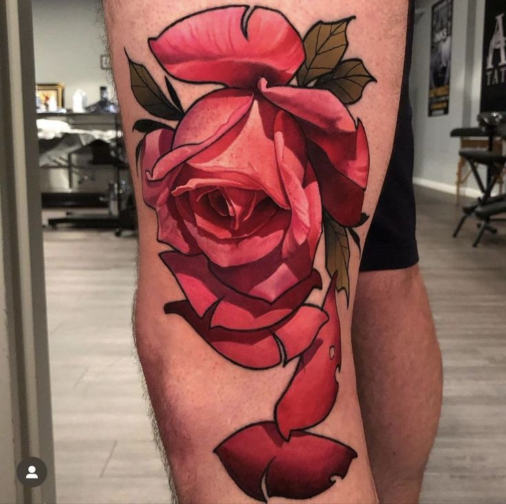 a man's leg with a rose tattoo on it