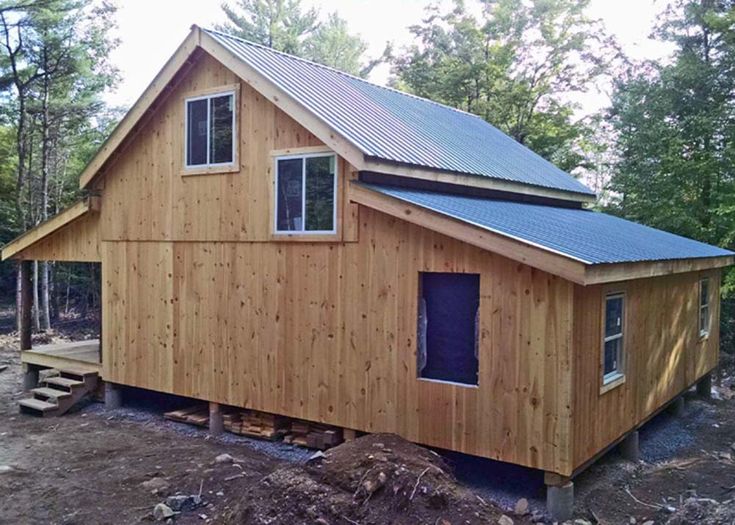 a small wooden house with a metal roof and windows on top of it's side