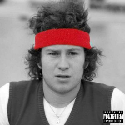 a young man with curly hair wearing a red headband