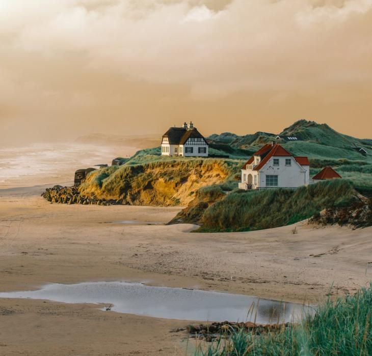 the houses are on top of the hill by the water