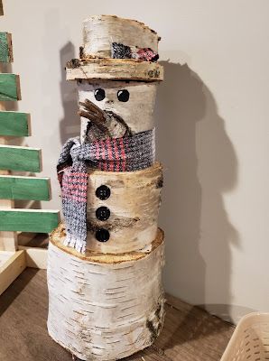 a snowman made out of birch tree trunks