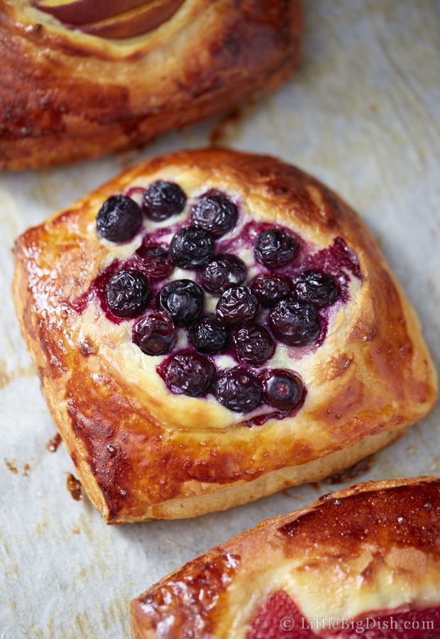 baked pastries with blueberries and raspberries on them