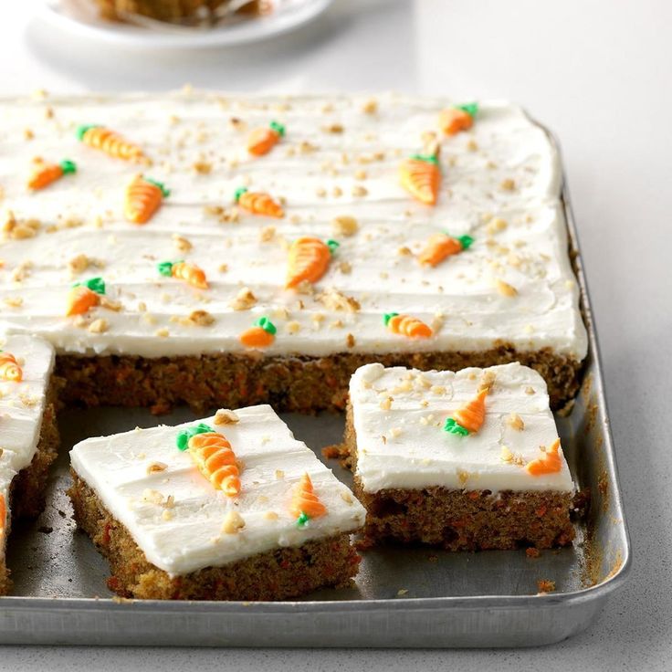 carrot cake with white frosting and green sprinkles on a metal pan