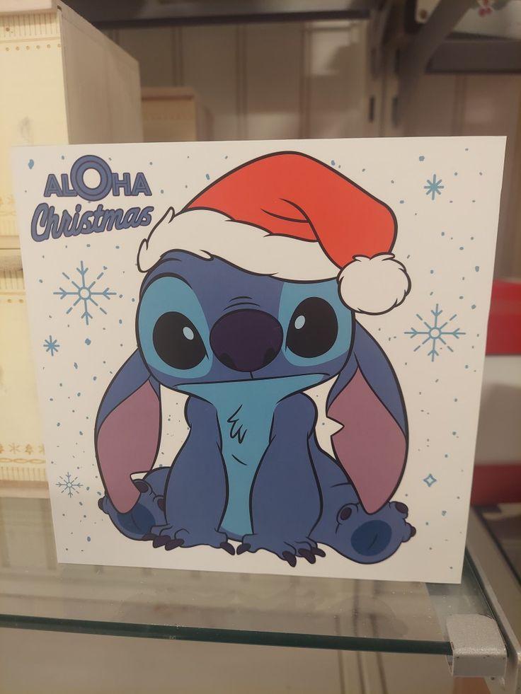 a christmas card with a cartoon character wearing a santa hat on it's head