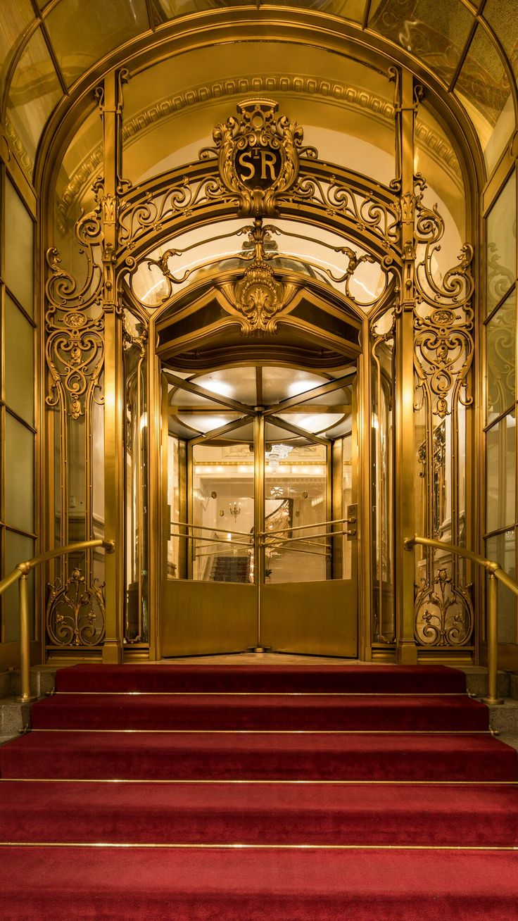 an ornate entrance to a building with red carpet