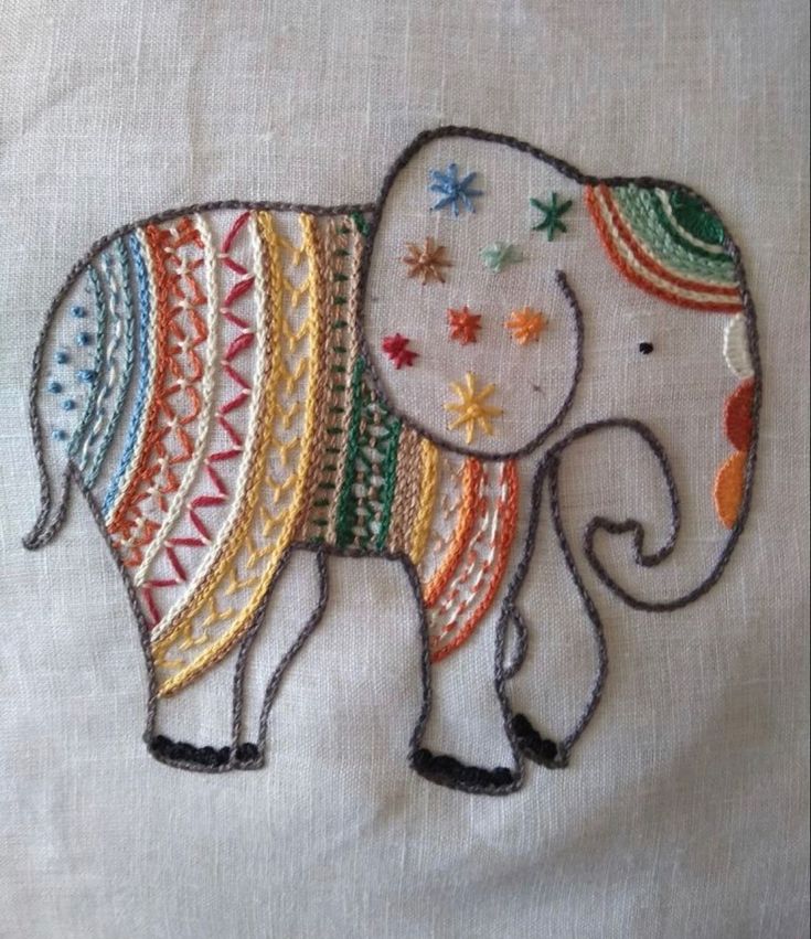 an embroidered elephant is shown on a white cloth