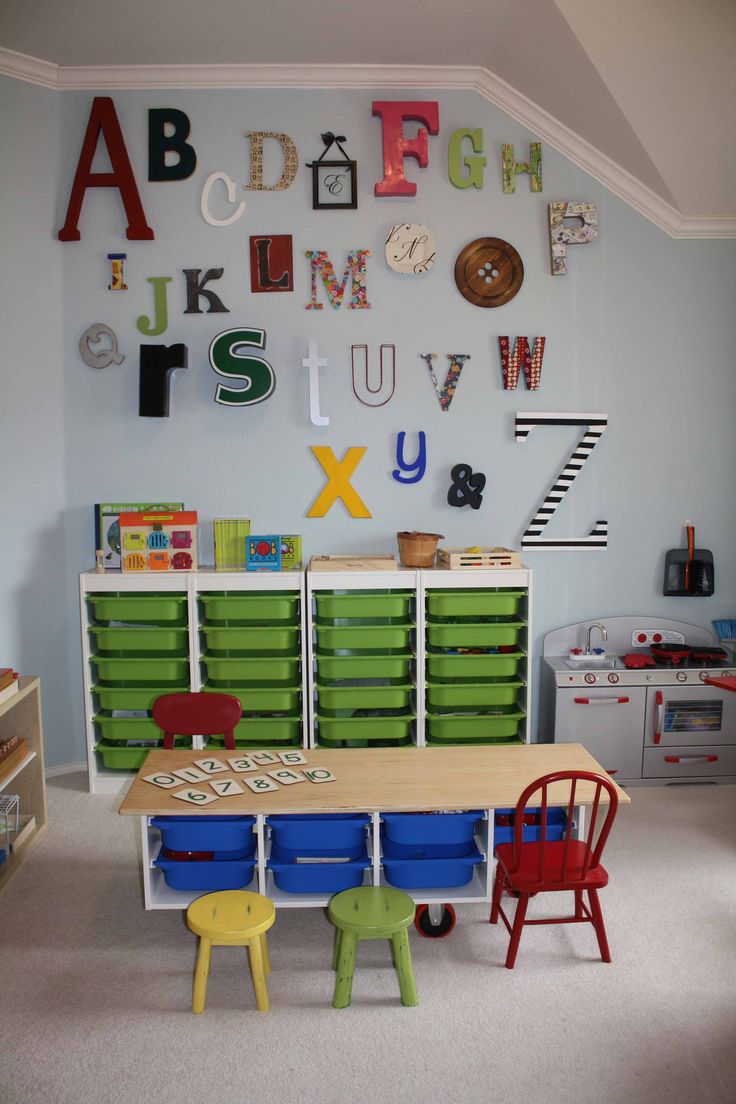 a child's room with lots of toys and letters on the wall