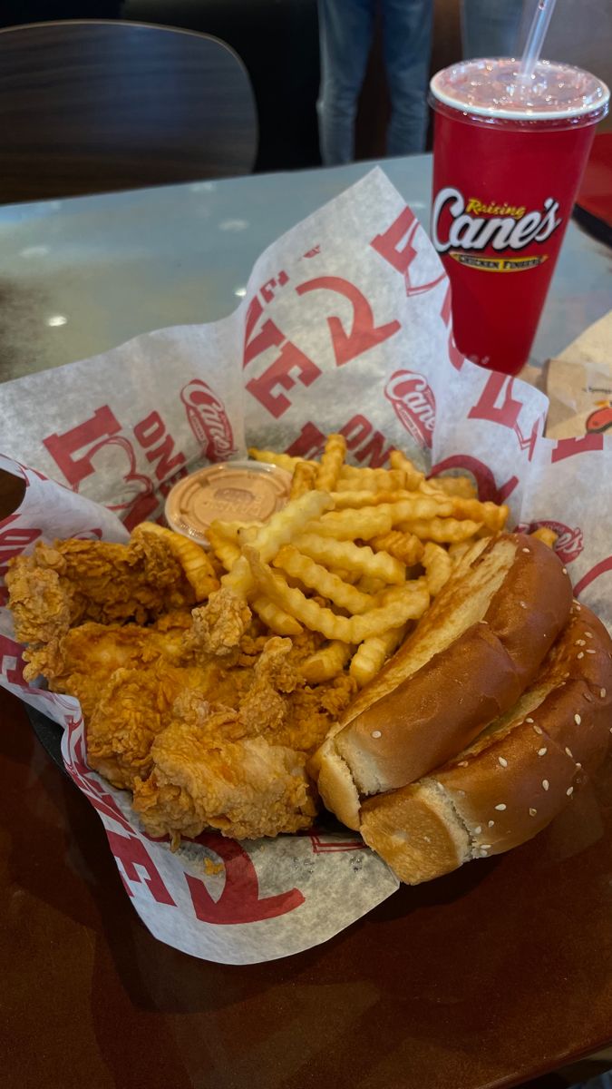 fried chicken and french fries on a plate next to a cup of sauce