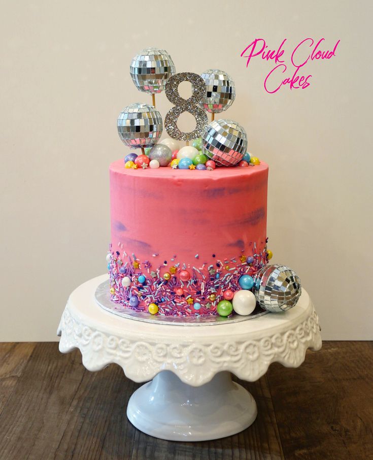 a birthday cake with pink frosting and decorations on top is decorated with the number eight