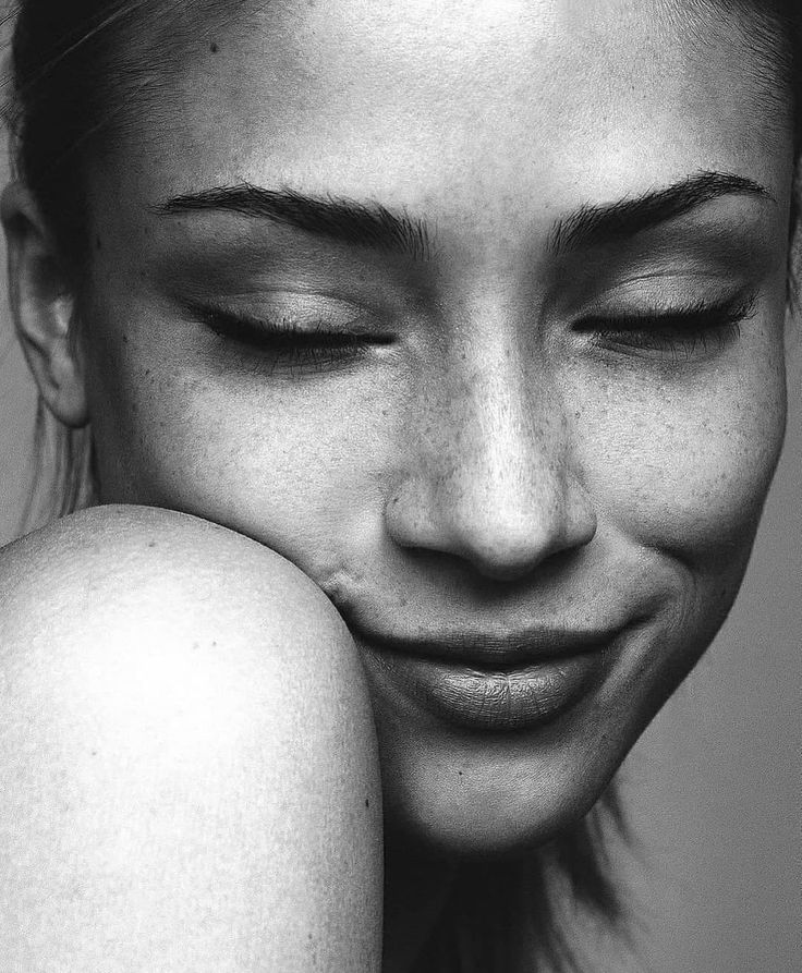 a black and white photo of a woman with her eyes closed