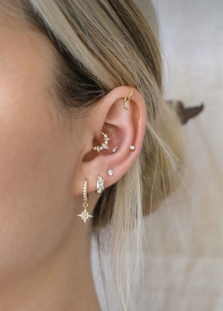 a woman wearing ear piercings with stars on them