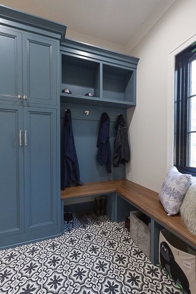 a room with some blue cabinets and black and white floor tiles on the floor next to a window