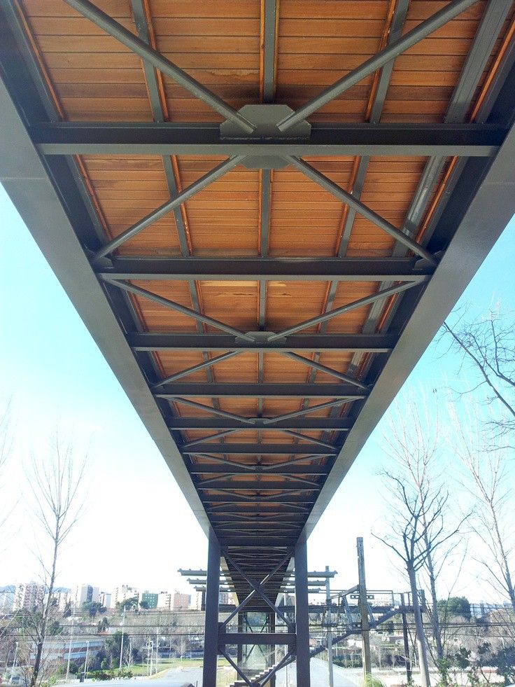 the underside of a covered walkway with trees in the background