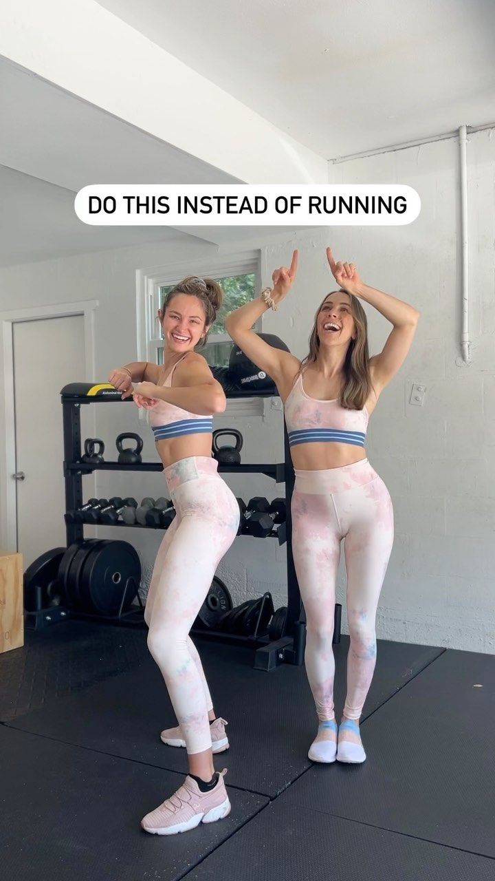 two women in matching sports bras and leggings posing for the camera with their arms up