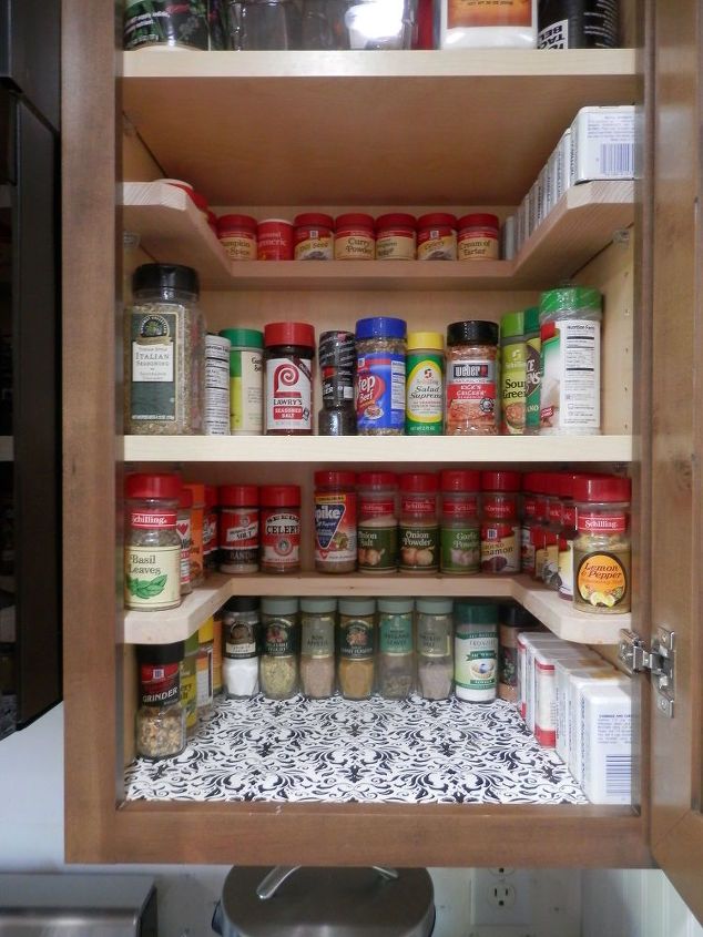 an open cabinet with spices and condiments in it