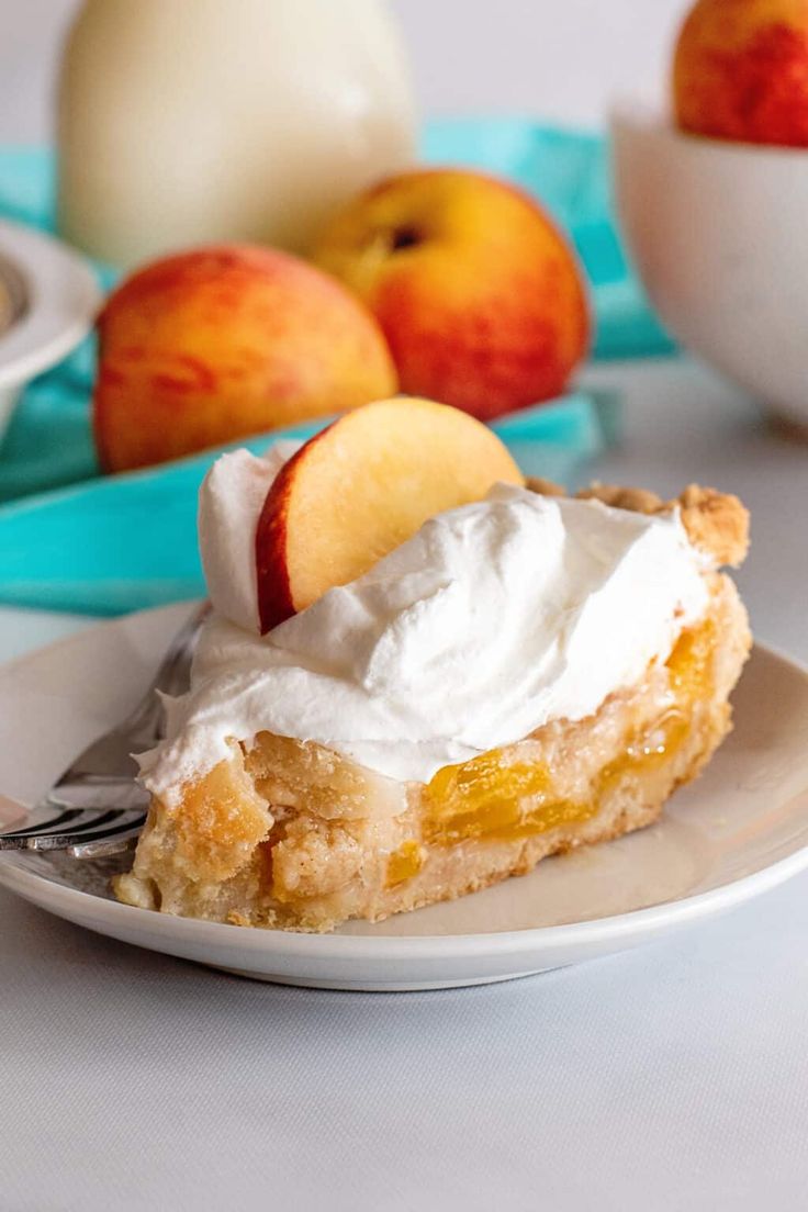 a piece of pie with whipped cream and apples in the background