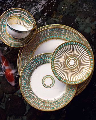 three plates and two bowls sitting on top of each other next to a gold fish