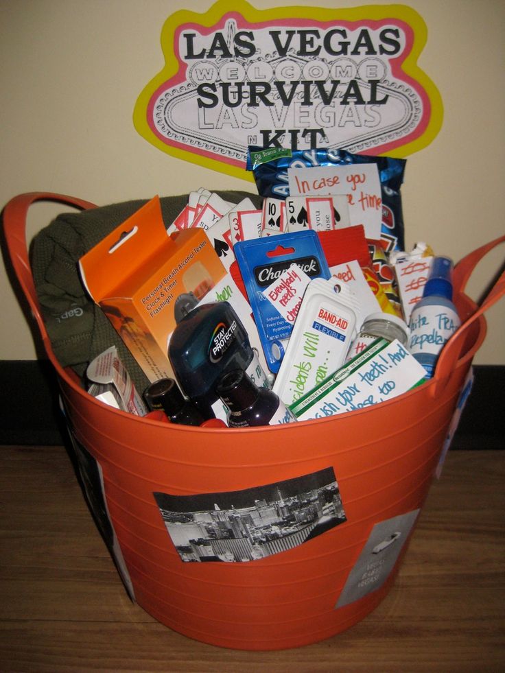 an orange bucket filled with assorted items sitting on top of a wooden floor next to a sign