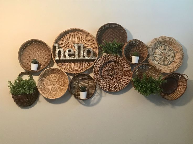 several baskets with plants and the word hello written on them are arranged in front of a white wall