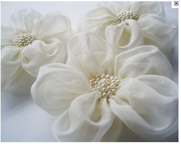 three large white flowers with pearls on them