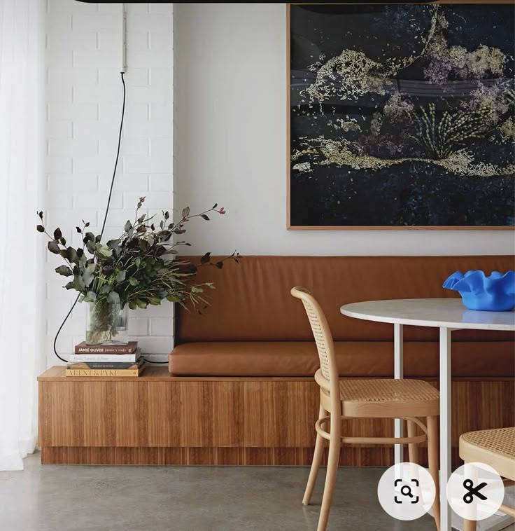 a table and chairs in a room with a painting on the wall above it that reads 8x8