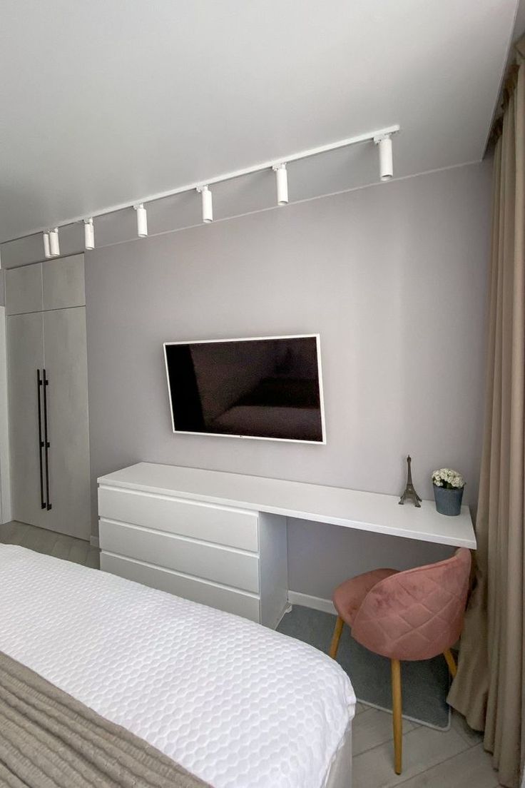 a bedroom with a large flat screen tv on the wall