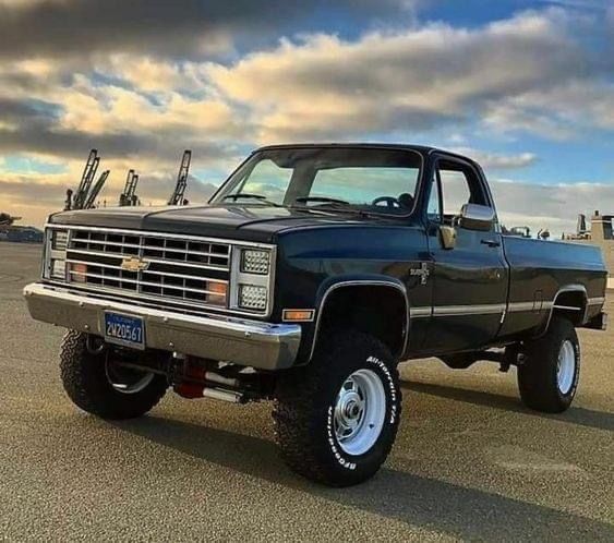 a black truck parked on top of a parking lot