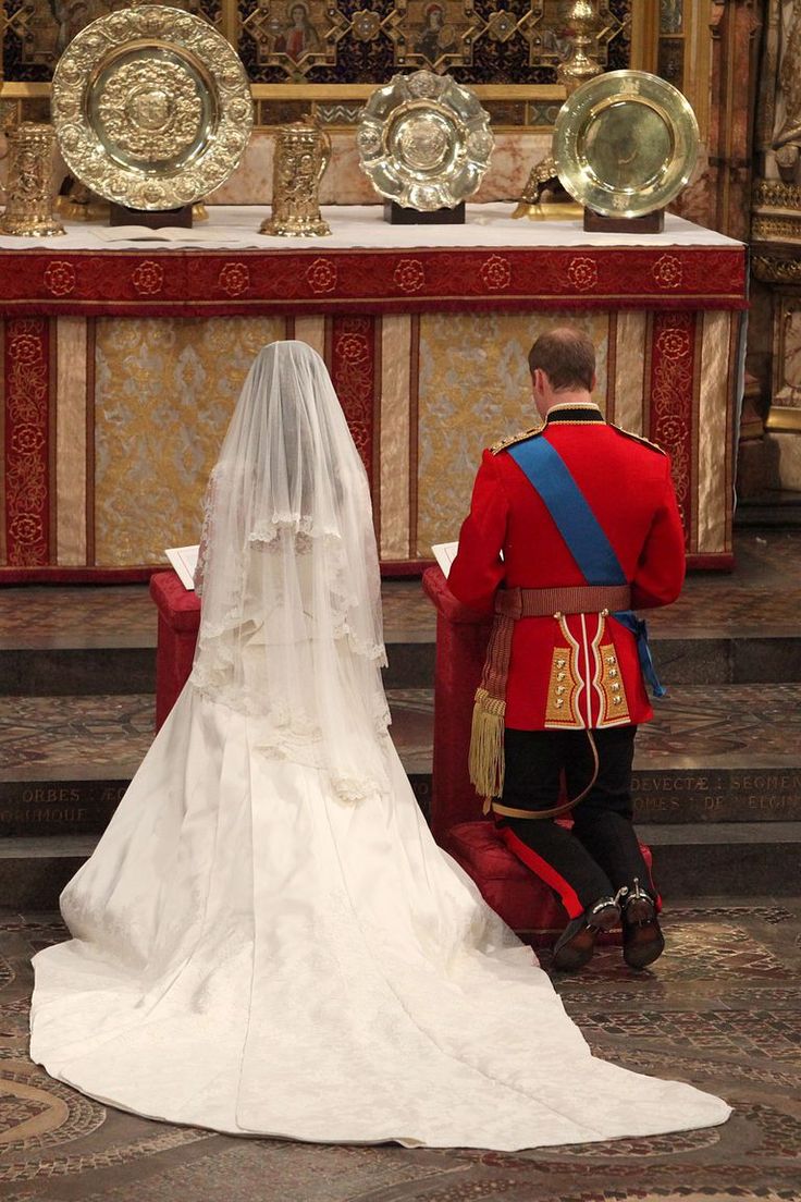 the bride and groom are looking at each other in front of an alterp with gold plates