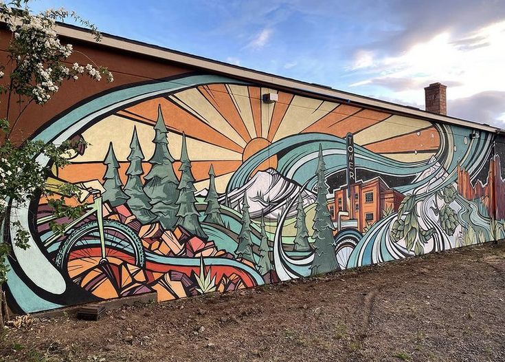 a large mural on the side of a building with trees and buildings in the background