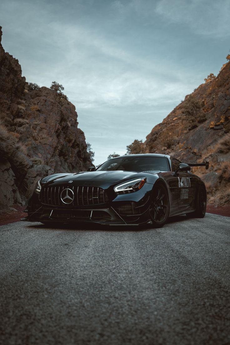 a black sports car parked on the side of a mountain road