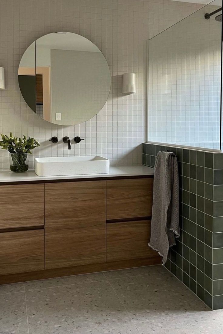 a bathroom with a sink, mirror and tiled walls