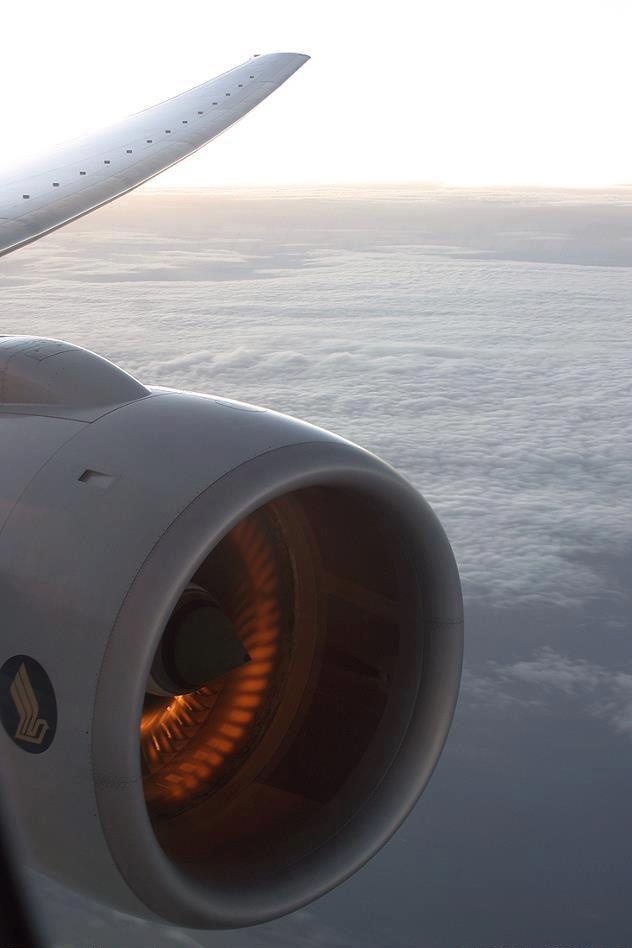 the view from inside an airplane looking down at the wing and engine with bright orange lights