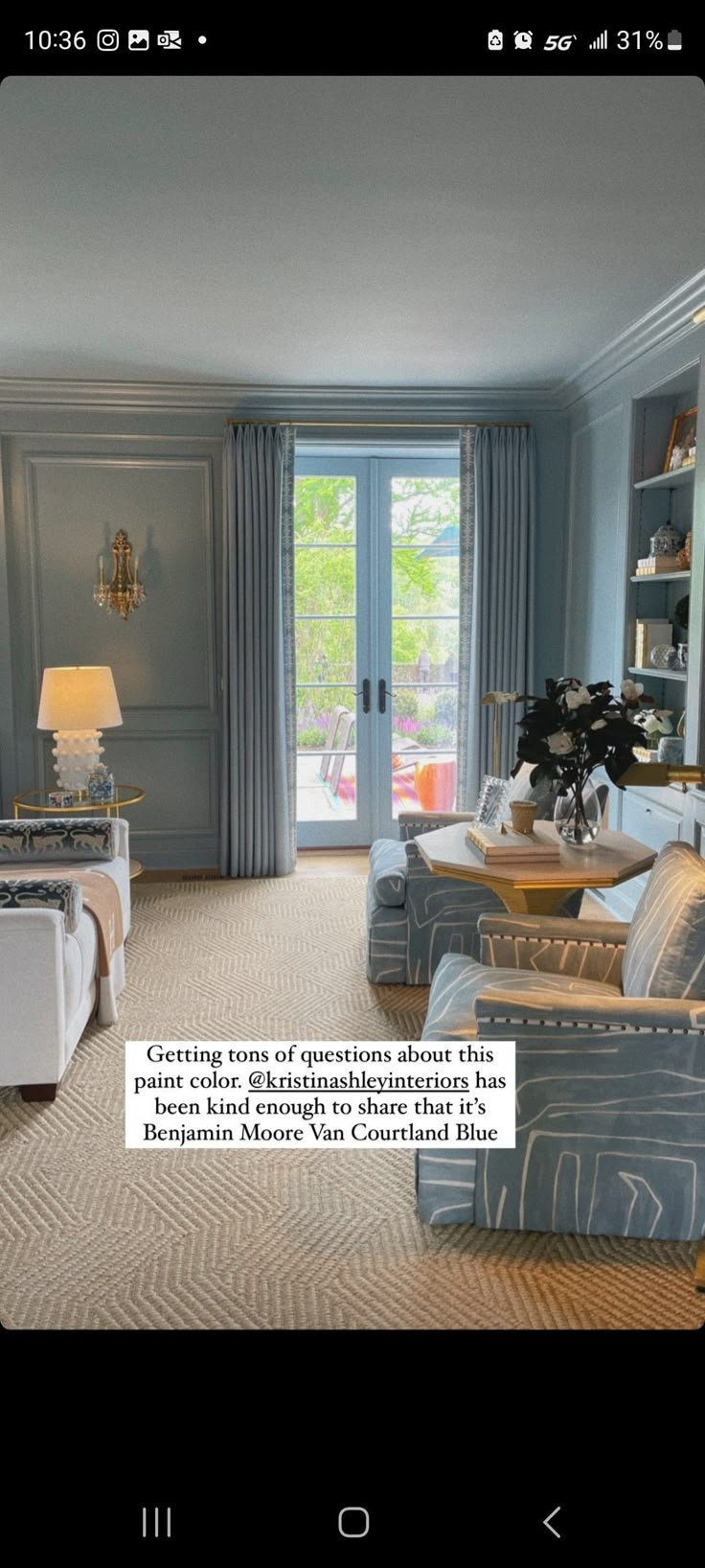 a living room filled with furniture and a door leading to another room that has french doors