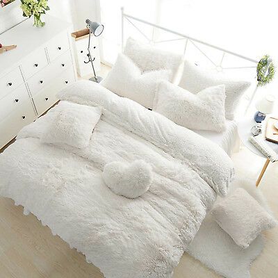 the bed is made with white fluffy blankets