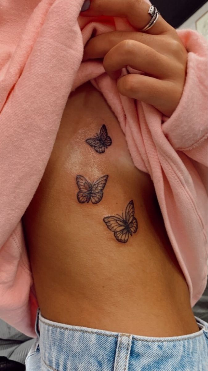 a woman's stomach with three butterflies on her side and the bottom part of her belly