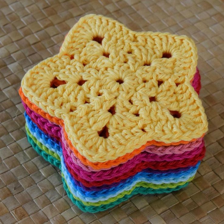 four crocheted coasters are stacked on top of each other